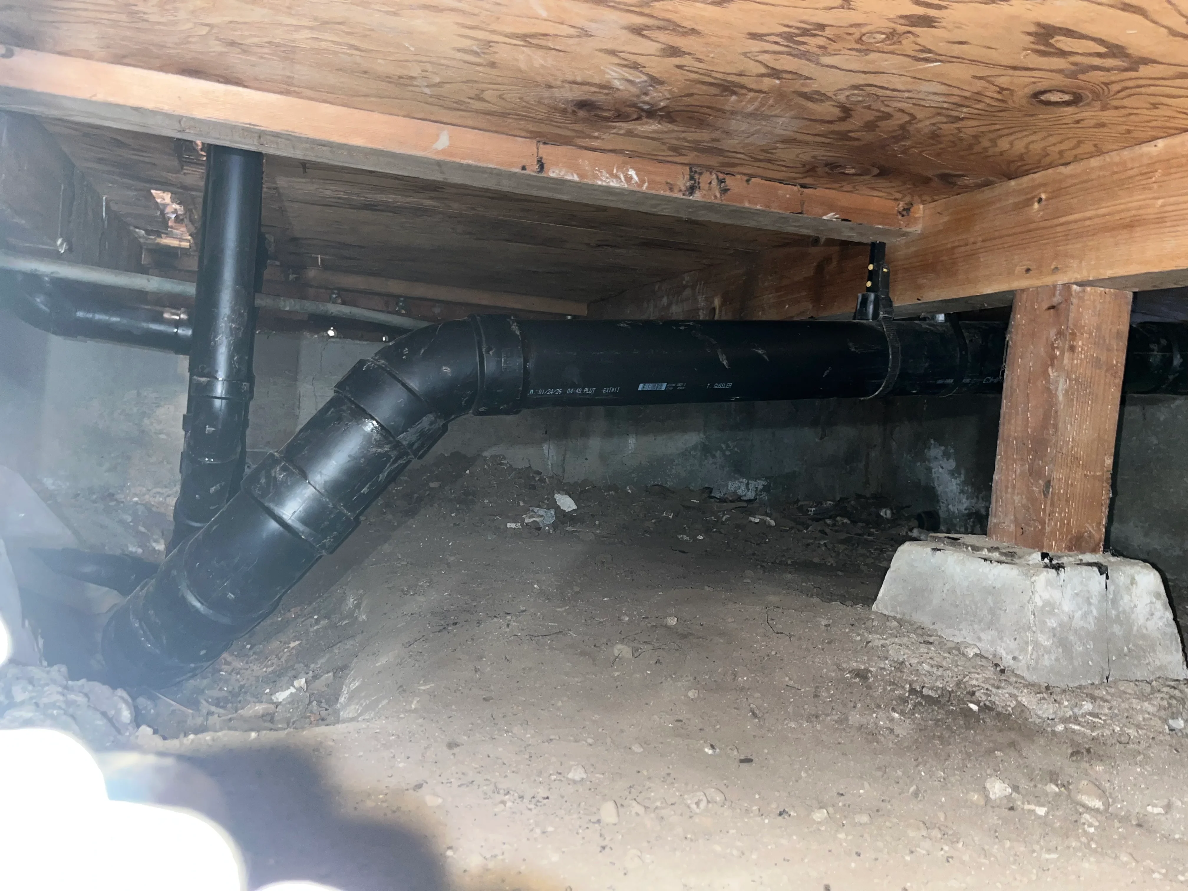 Black sump pump with discharge pipe in basement foundation installation