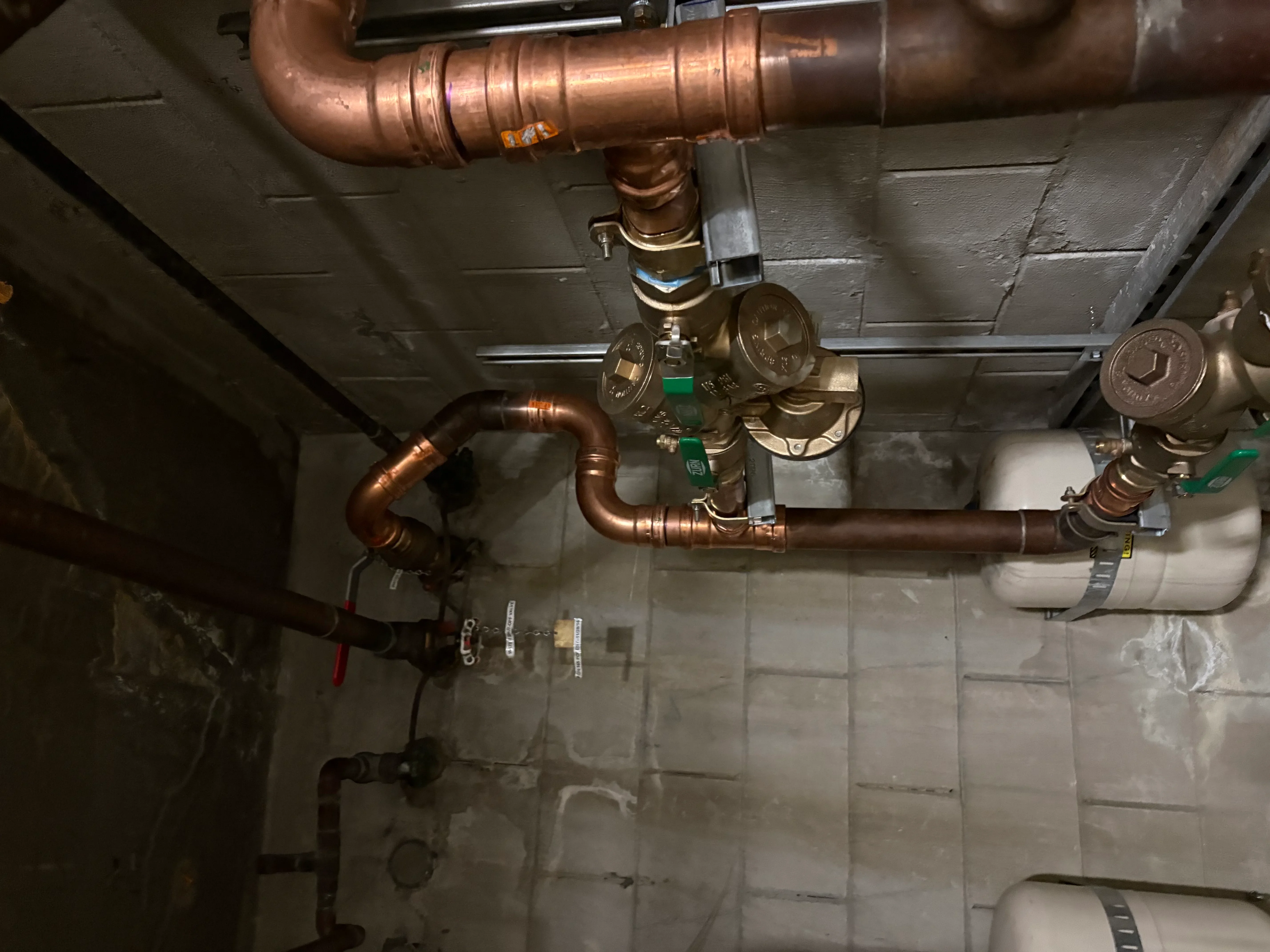 Copper radiant heating manifold with flow meters, pump, and soldered piping connections