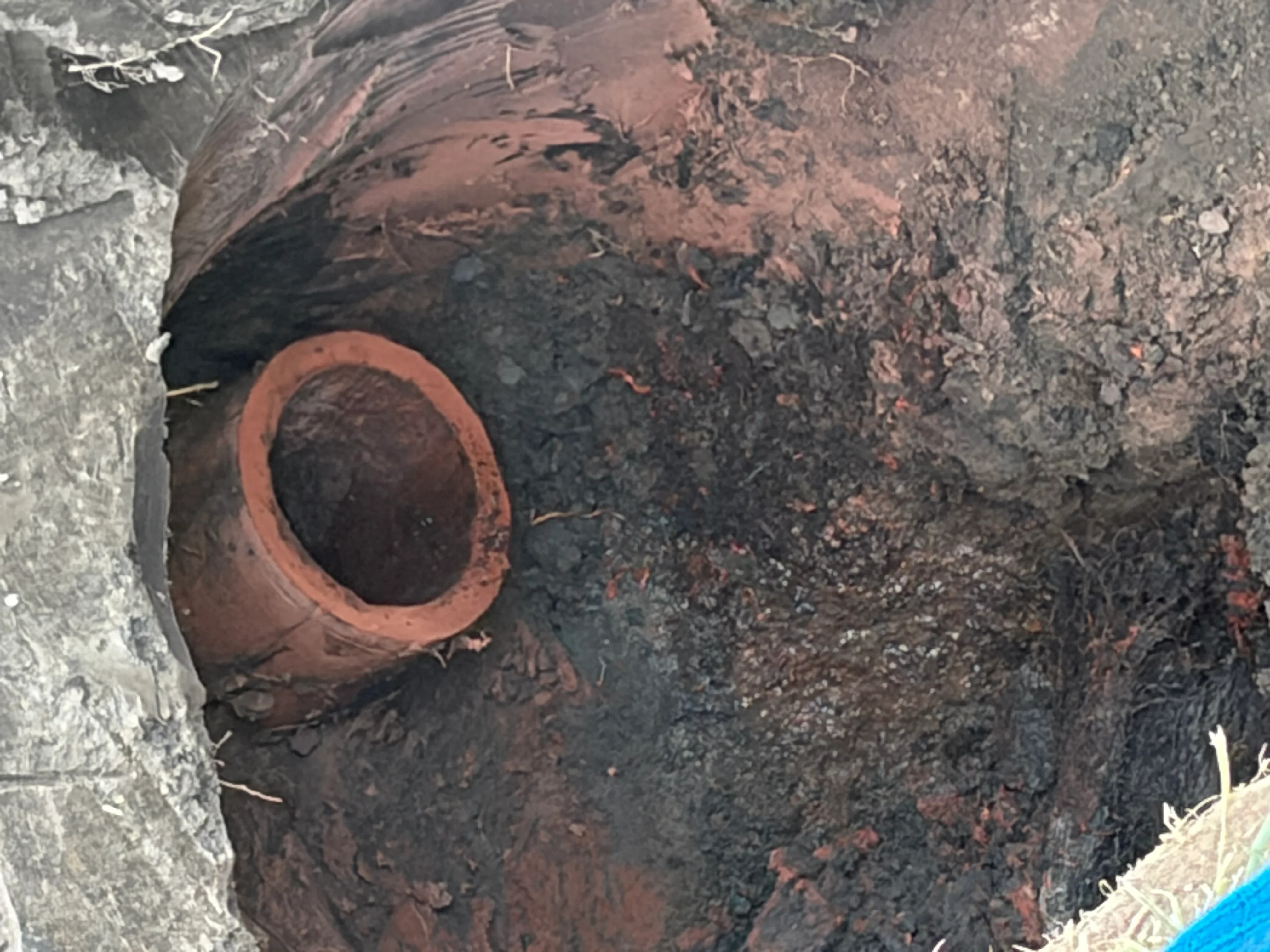 Corroded cast iron drain pipe with rust and scale buildup, interior view
